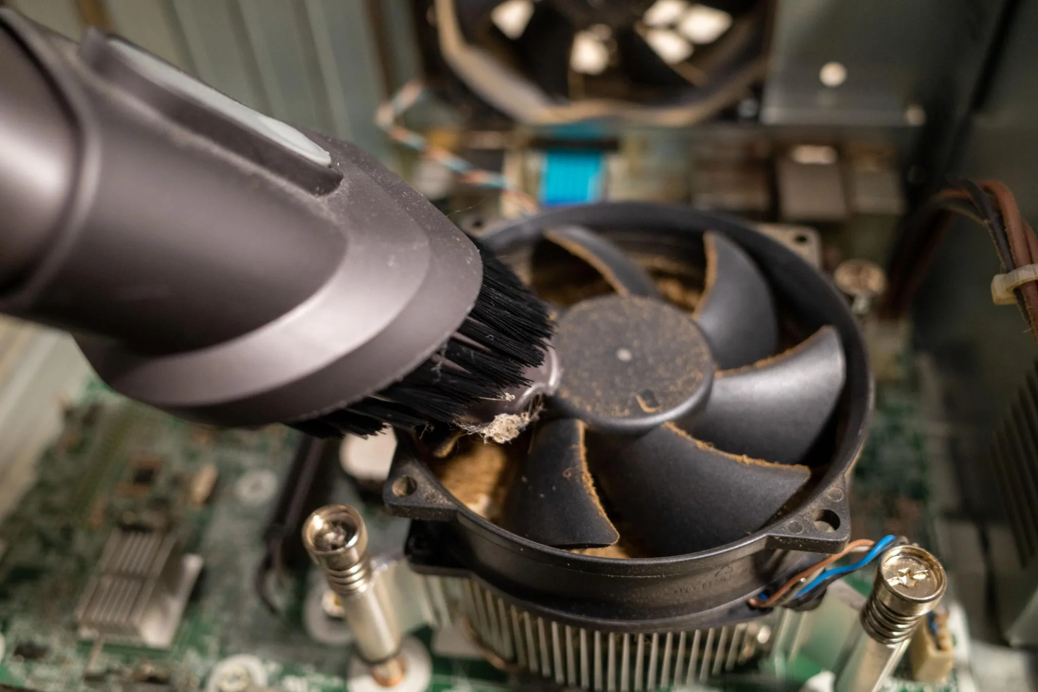 CPU cooler being cleaned of accumulated dust during a thermal-management service
