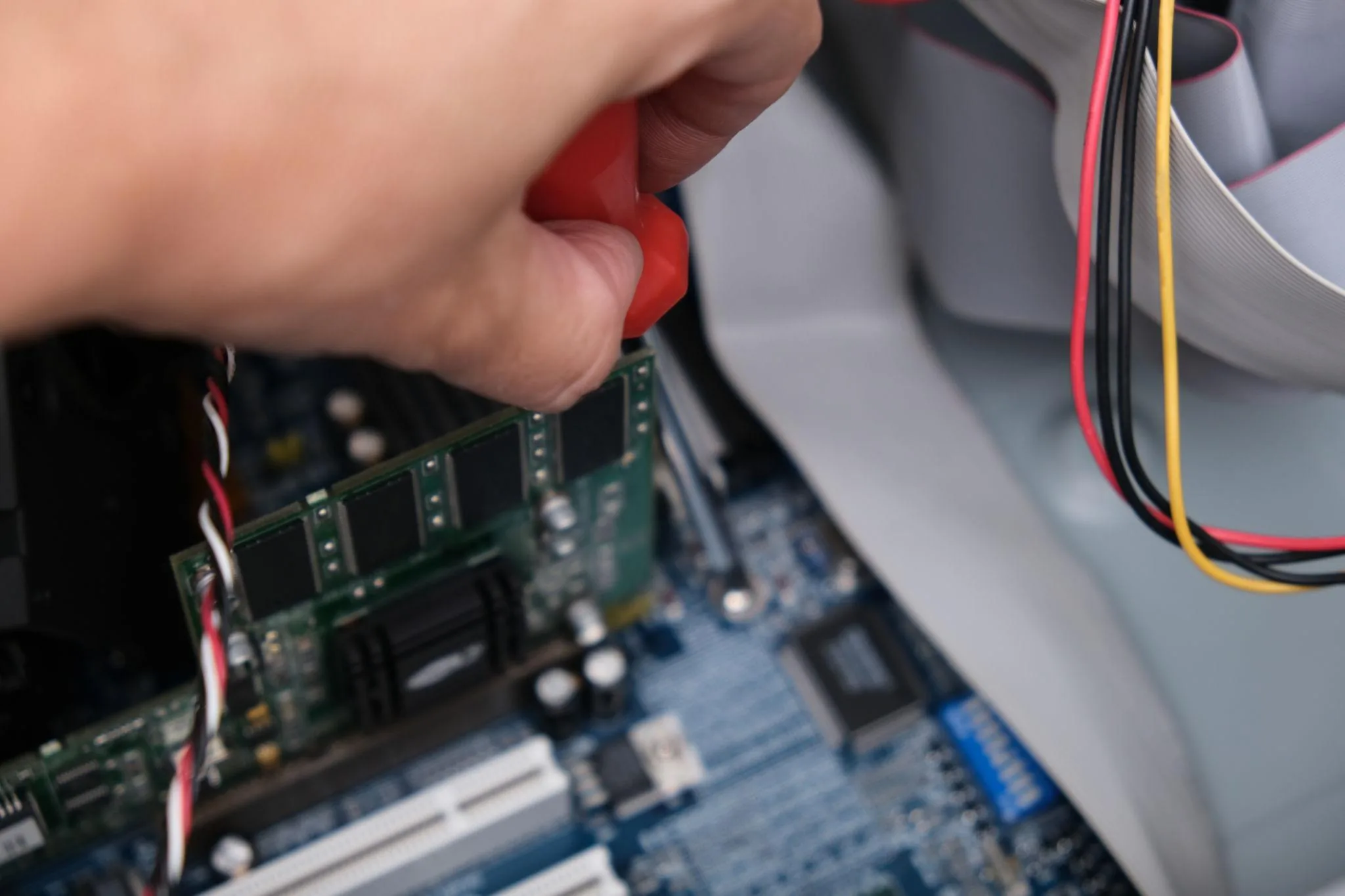 Hands installing components inside a desktop PC chassis during service